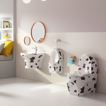Bathroom with children's toilet and sink set featuring a cow print design.